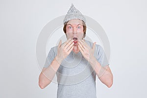 Young man with tinfoil hat as conspiracy theory concept looking shocked