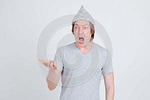 Young man with tinfoil hat as conspiracy theory concept looking shocked