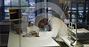 Young man, tired and sleeping at desk for night research, accounting deadline and career stress in office. Business