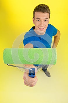 Young man top view holding paint roller.