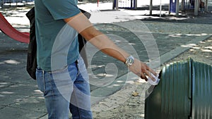 Young man tossing junk in garbage bin