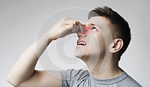 Young man touching his bleeding nose, panorama