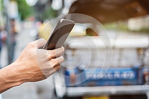 Young man tourist or casual businessman ordering taxi via cab application on smartphone in city street, Male traveler using mobile