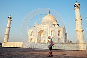 Young man tourist looking to the Taj Mahal in Agra, India . concept of culture, tourism and religion