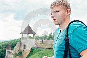 Young man tourist on the old castle territory