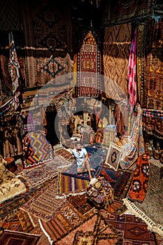 Young man tourist at an old traditional Turkish carpet shop in cave house Cappadocia, Turkey Kapadokya