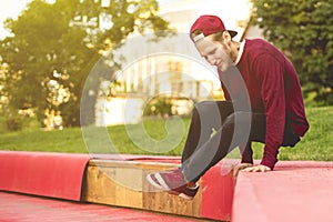 Young man tracer in causual doing parkour in city on a summer day