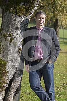 Young man in trachten under a tree
