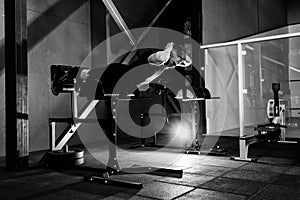 Young man training back muscles. Muscular athlete exercising. Full body length portrait.