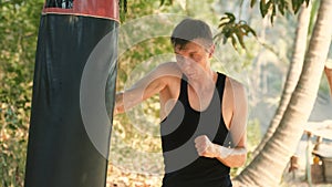 young man training with a punching bag in the jungle