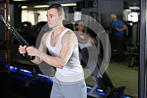 Young man training with straps in gym