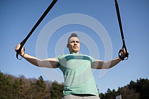 Young man, training with suspensions