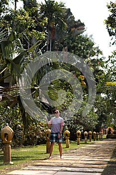 Young man travaler walking in a palm park on Ko Chang, Thailand in April, 2018 - Best travel destination for happiness