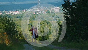 Young man traveler with big backpack walking in the forest in windy weather