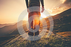 Young Man Traveler feet standing alone with sunset mountains on background