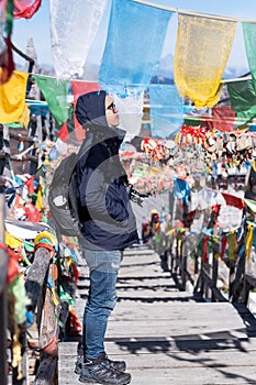 Young man traveler with sweater and backpack traveling in Shika snow mountain, happy Asian hiker enjoy in trip Zhongdian city