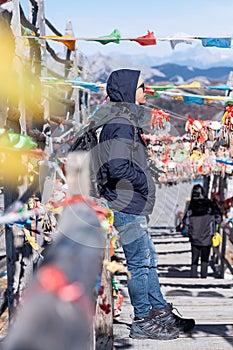 Young man traveler with sweater and backpack traveling in Shika snow mountain, happy Asian hiker enjoy in trip Zhongdian city