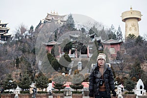 Young man traveler with sweater traveling in Shangri-La Golden temple or Dafo temple With giant Spinning Golden Wheel at Dukezong