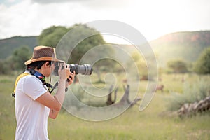 Young man traveler taking photo of wildlife animals