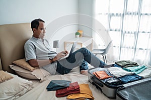 Young man traveler using laptop to looking departure schedules via online application