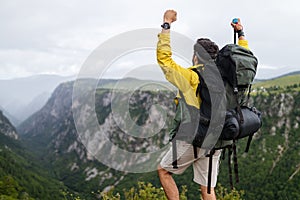 Young man traveling with backpack hiking in mountains