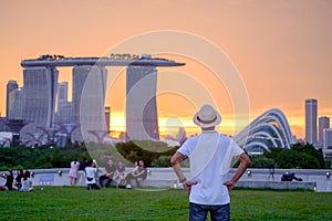 Young man traveling with hat at Sunset, solo Asian traveler visit in Singapore city downtown. landmark and popular for tourist
