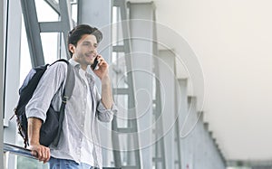 Young man traveller talking on mobile phone in airport
