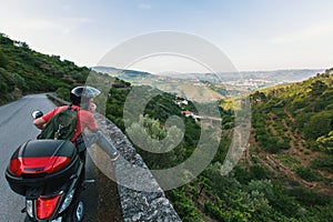 Young man travels on a motorcycle stopped at a view point and looking at the Douro Valley