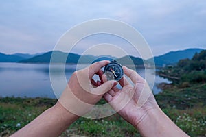 Young man trekker searching direction with a compass enjoy traveling with backpack, hiking concept, travel concept