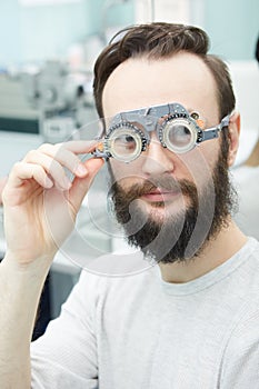 Young man with trial frames in ophthalmologist clinic
