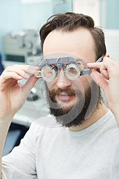 Young man with trial frames in ophthalmologist clinic