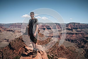 Young man trousist standing in front of Grand Canyon. Hiker with backpack enjoying view, USA. Travel and outdoort