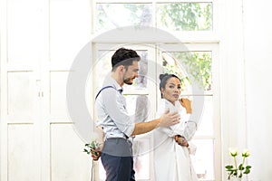 Young man trying to reconcile his girlfriend offering white rose