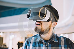 Young man trying vr goggles in the shopping centre photo