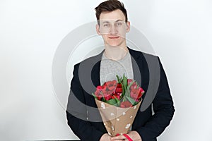 Young man with tulips, bouquet of spring flowers
