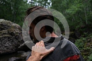 Young man turning around. a hand on a shoulder