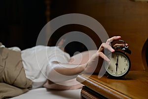 Young man turning off the alarm clock