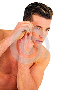 Young man tweezing eyebrows