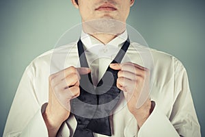 Young man tying a bow tie