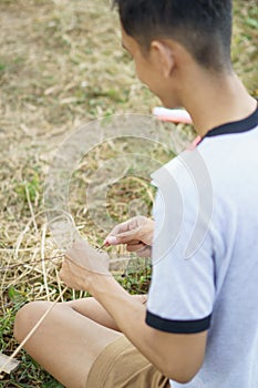 Young man is tying a rope