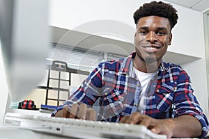 Young man typing on computer keyboard in office