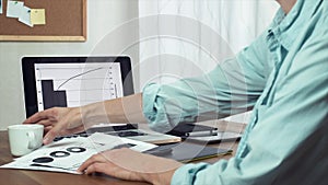 Young man typing message using tablet and laptop computer