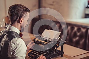 Young man typing on a retro typewriter