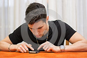 Young man typing a text message on his phone