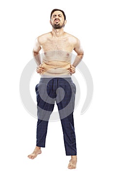 A young man is unhappy with fat on his stomach. Isolated over white background.