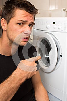 Young man unhappy with washing mashine