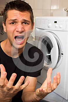 Young man unhappy with washing mashine