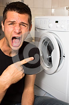 Young man unhappy with washing mashine