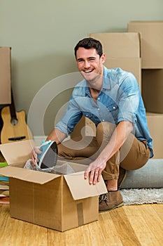 Young man unpacking carton boxes