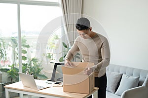 Young man unpacking received parcel